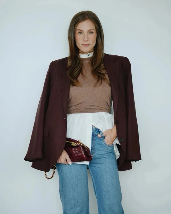 Model wearing an oversized burgundy blazer over a white shirt and jeans